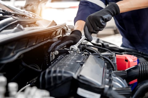 Manos de mecánico trabajando en el motor de un automóvil
