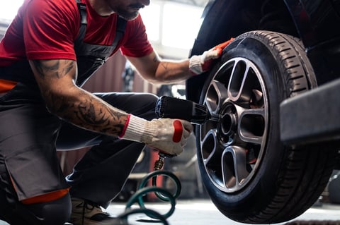 Mecánico profesional instalando llantas con pistola neumática