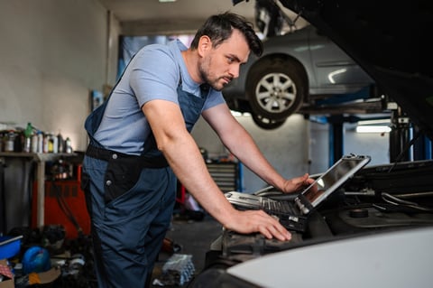 Técnico automotriz certificado usando equipo de diagnóstico en taller